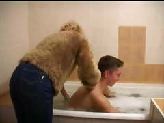 Older woman gives young man bath